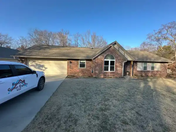 A brick ranch with a white company truck in the drive